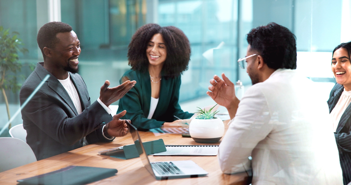 Businesspeople meet around a conference table.