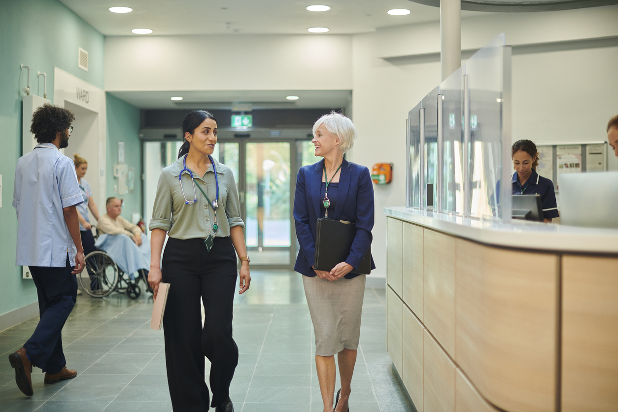 A Health Services Management Specialist Talks With a Physician in a Hospital Corridor..jpg