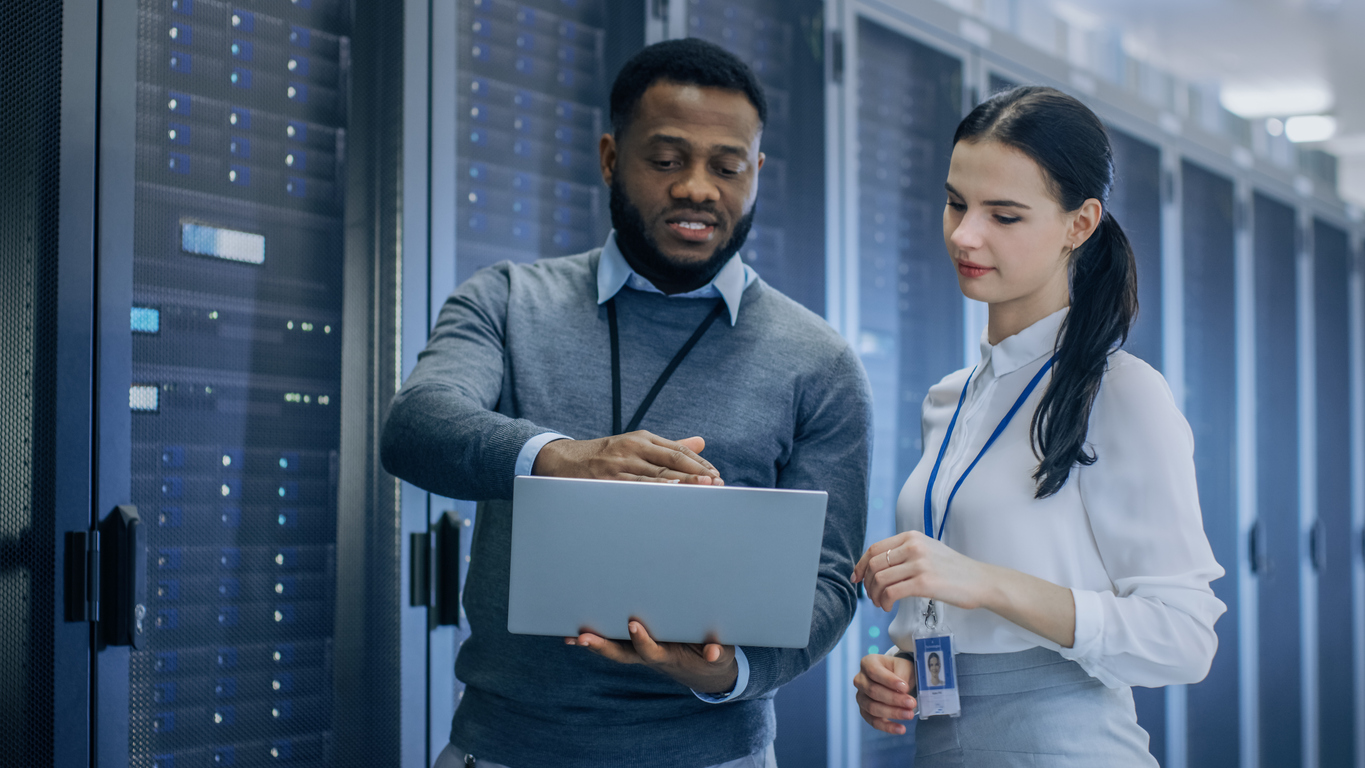 It Professionals in a Server Room Read a Laptop