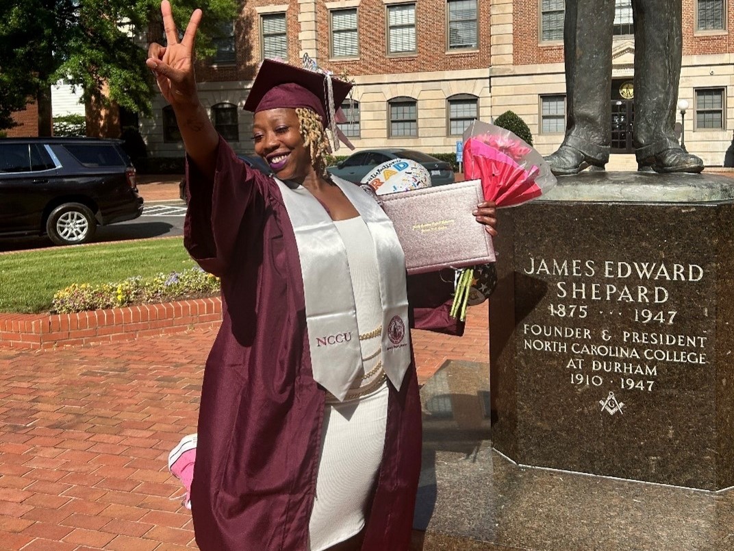 Sherika Lenoir standing in a graduation cap and gown