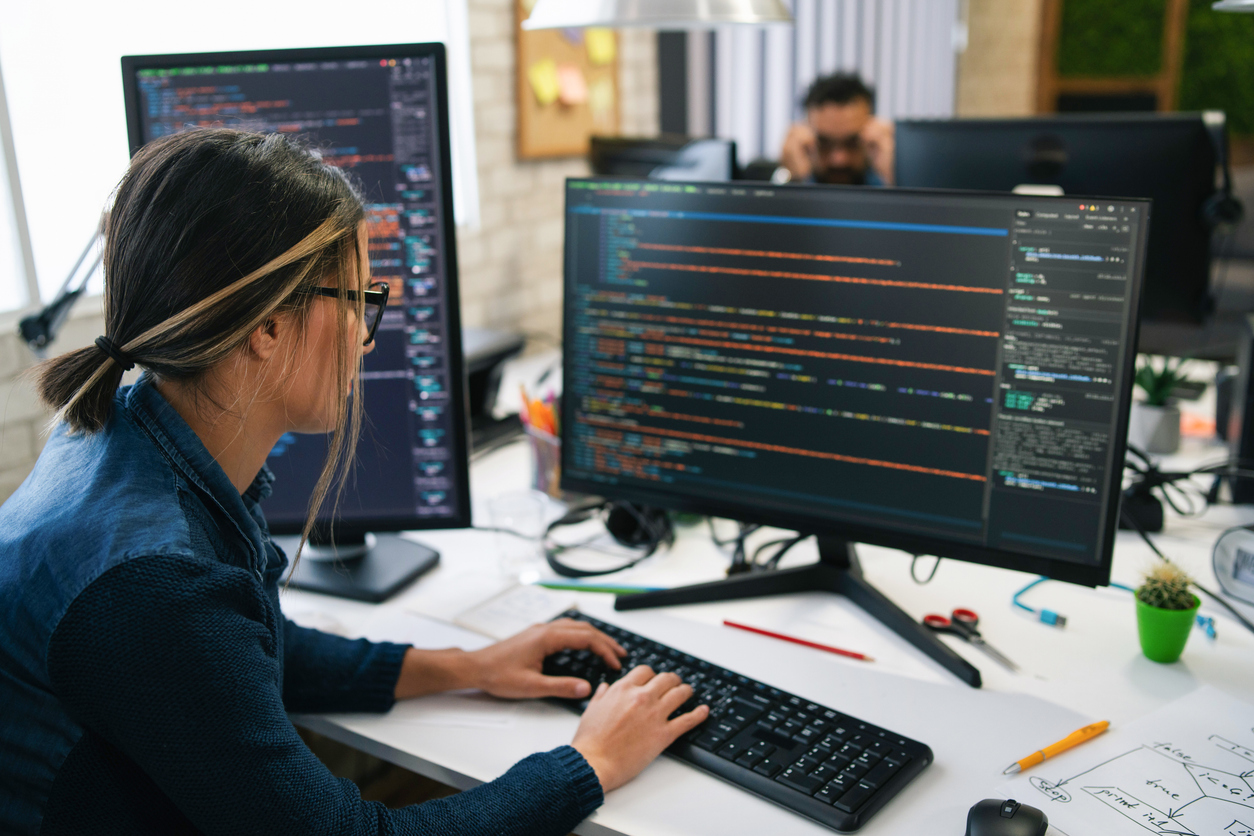 An It Professional Reviews Code on a Monitor