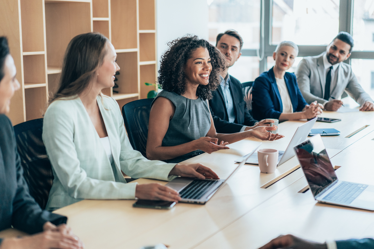Business leaders meet around a conference table.
